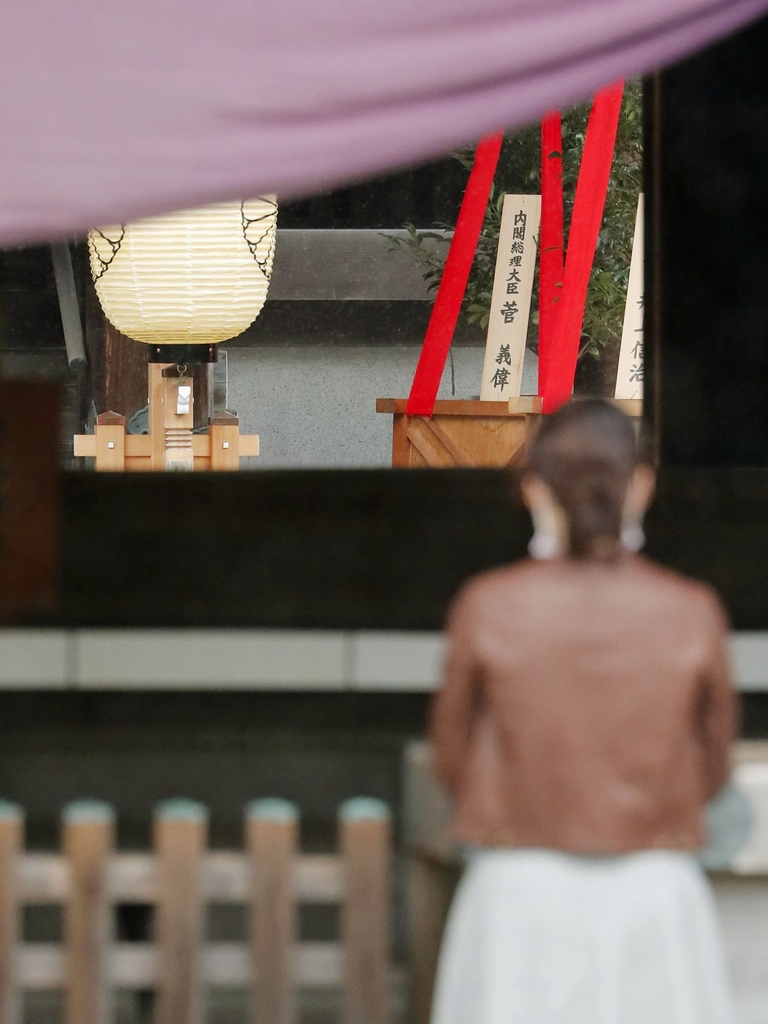 (도쿄 교도=연합뉴스) 스가 요시히데(菅義偉) 일본 총리가 17일 야스쿠니(靖國)신사의 가을 큰 제사(추계예대제)에 맞춰 '마사카키'(木+神)로 불리는 공물을 봉납했다. 이날 한 참배객이 야스쿠니 제단에 놓인 스가 총리 명의의 '마사카키' 앞에서 예를 올리고 있다. parksj@yna.co.kr