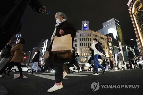 (도쿄 AP=연합뉴스) 일본의 코로나19 하루 확진자가 처음으로 6천 명을 넘은 6일 밤 마스크를 착용한 도쿄 시민들이 긴자 쇼핑가의 횡단보도를 건너고 있다