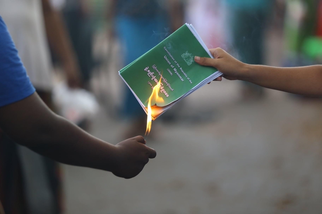 양곤에서 시위대가 2008년 헌법 책자를 불태우고 있다. 2021.4.1