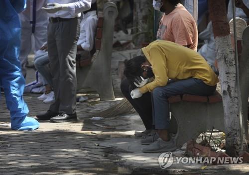 19일 인도 수도 뉴델리의 코로나19 시신 화장장에서 친척의 죽음을 슬퍼하는 남성. [AP=연합뉴스]