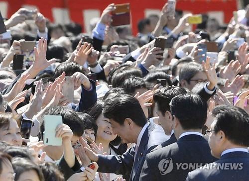 2019년 4월 신주쿠 교엔에서 열린 '벚꽃 모임' 행사에서 아베 신조 총리가 참가자들과 손을 마주치고 있다. [교도=연합뉴스 자료사진] 