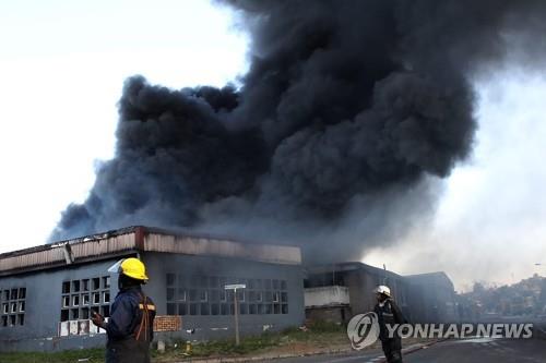 지난 14일 더반 외곽의 한 공장이 소요 와중에 불타고 있다. 