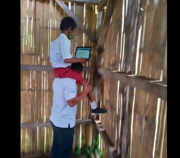 인터넷 신호 잡으려 교사 어깨에 목말 탄 인도네시아 학생