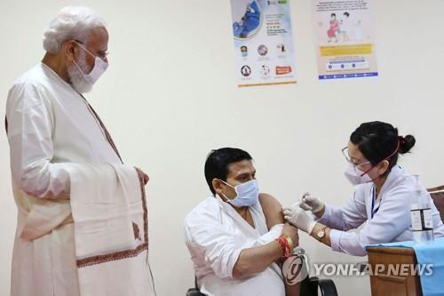  백신 접종 장면을 지켜보는 나렌드라 모디 인도 총리(왼쪽)