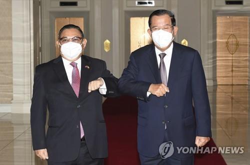 팔꿈치 인사하는 미얀마 군정 외교장관(왼쪽)과 훈센 캄보디아 총리. 2021.12.7