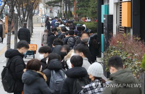Las personas esperan en fila para someterse a las pruebas del coronavirus, el 29 de noviembre de 2021, en una clínica provisional, en el distrito Songpa, en Seúl.