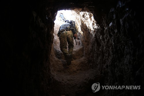 IS가 만들어 놓은 땅굴을 지나고 있는 쿠르드 페시메르가군 [AP=연합뉴스]