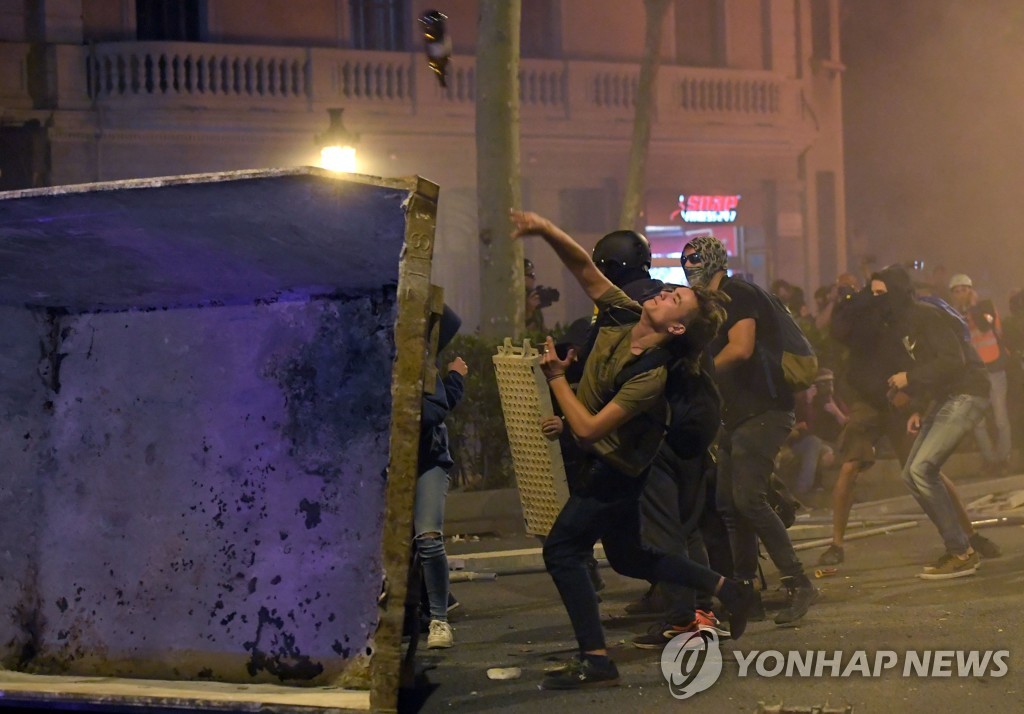 16일 저녁(현지시간) 스페인 카탈루냐 제1도시 바르셀로나의 거리에서 시위대가 경찰에 돌을 던지며 격렬한 시위를 벌이고 있다. [AFP=연합뉴스]