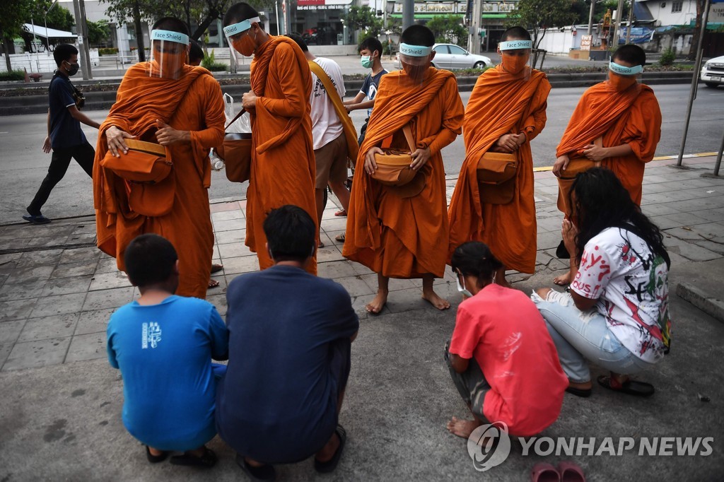 '코로나19 위험에 가리개 쓰고'…시주하는 태국 수도승들