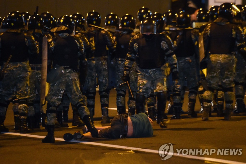 (AFP=연합뉴스) 야권 지지자들이 9일(현지시간) 벨라루스 수도 민스크에서 루카셴코 대통령의 대선 압승 결과에 항의 시위를 벌이는 도중 한 남성이 진압 경찰 앞에 누워있다. 