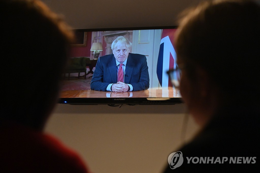 보리스 존슨 총리의 대국민 연설을 지켜보는 한 가정의 모습 [AFP=연합뉴스]