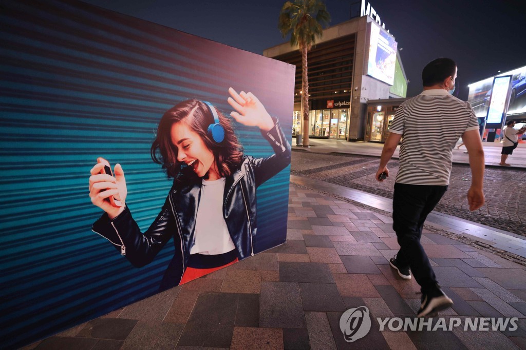 전자기기로 음악을 듣고 있는 사람이 걸린 광고판