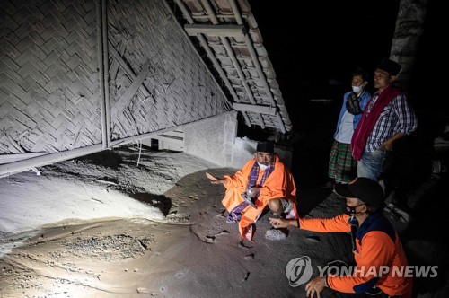 화산재에 묻힌 집을 수색하는 구조대원