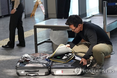 이스탄불공항에서 짐을 풀어 노트북을 꺼내는 이용객