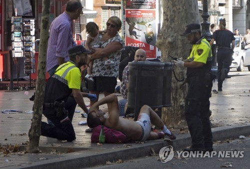스페인 바르셀로나 차량 테러 부상자를 살펴보는 경찰. [EPA=연합뉴스]