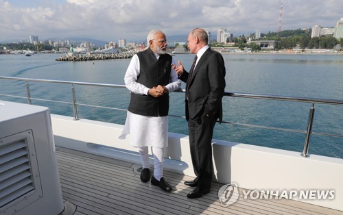 21일 러시아 소치에서 나렌드라 모디(왼쪽) 인도 총리와 블라디미르 푸틴 러시아 대통령이 함께 배를 타며 대화하고 있다. [EPA=연합뉴스]