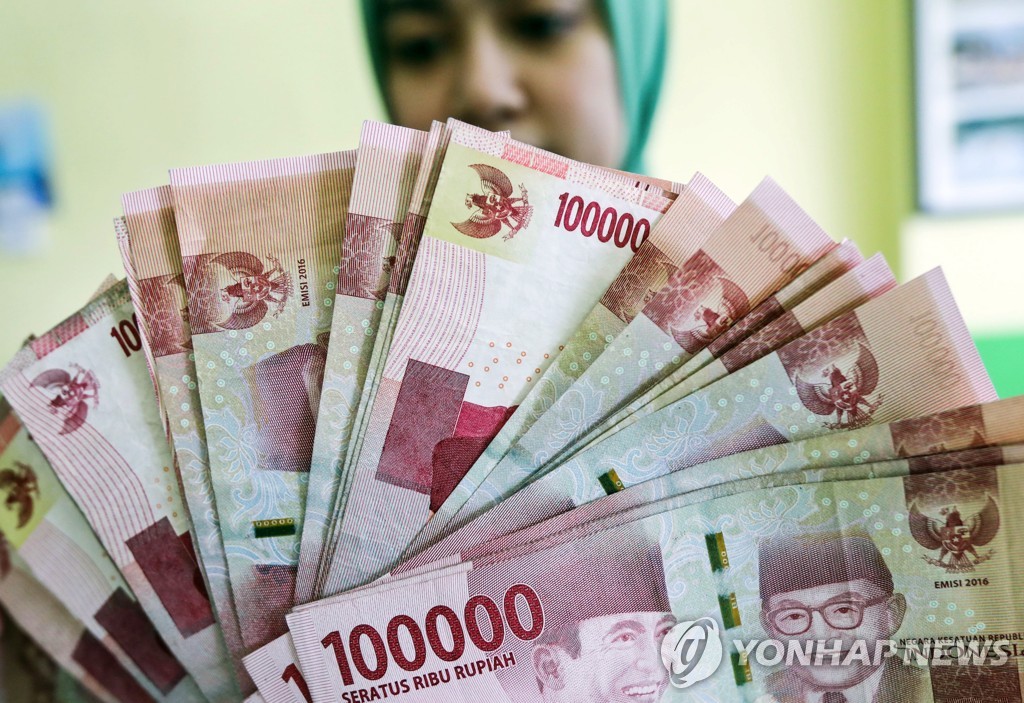 2018년 9월 20일 인도네시아 북수마트라 주 메단의 한 환전소 직원이 루피아화 지폐를 들어보이고 있다. [EPA=연합뉴스자료사진]
