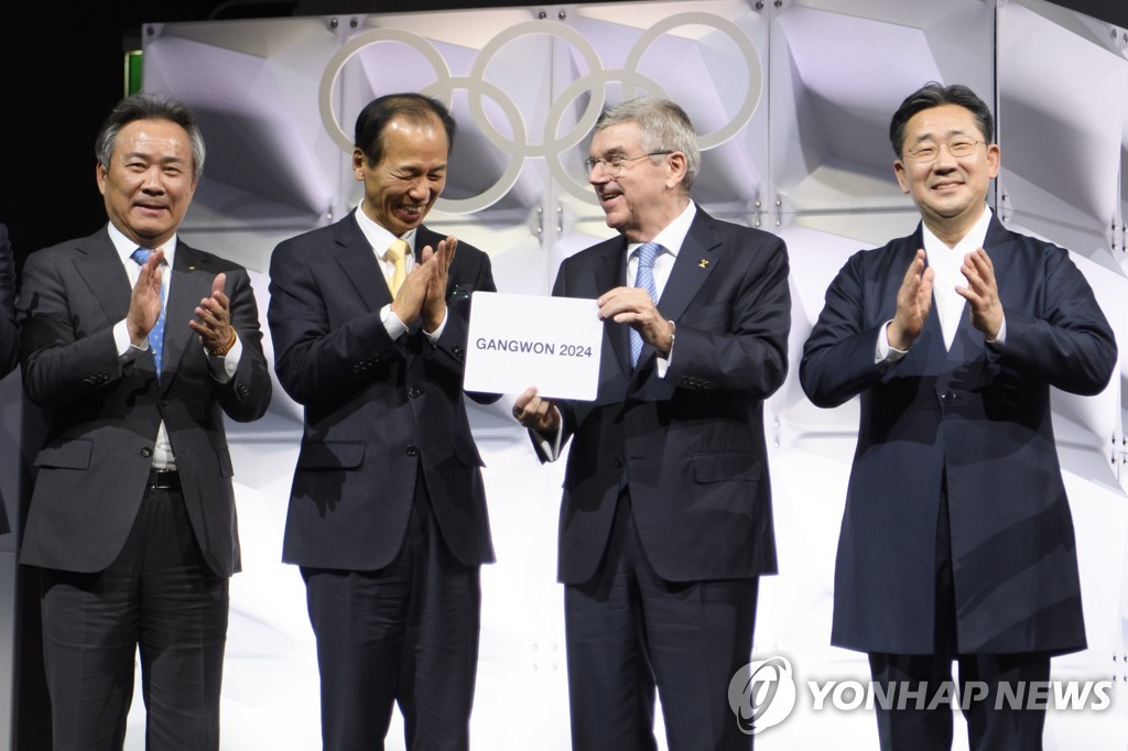 In this EPA photo, International Olympic Committee (IOC) President Thomas Bach (2nd from R) holds a card showing the name of Gangwon Province of South Korea as the host of the 2024 Winter Youth Olympics, following an election at the 135th IOC Session in Lausanne, Switzerland, on Jan. 10, 2020. Others with Bach are, from left: Lee Kee-heung, president of the Korean Sport and Olympic Committee, Choi Moon-soon, governor of Gangwon Province, and, to Bach's left, Park Yang-woo, South Korean minister of culture, sports and tourism. (Yonhap)
