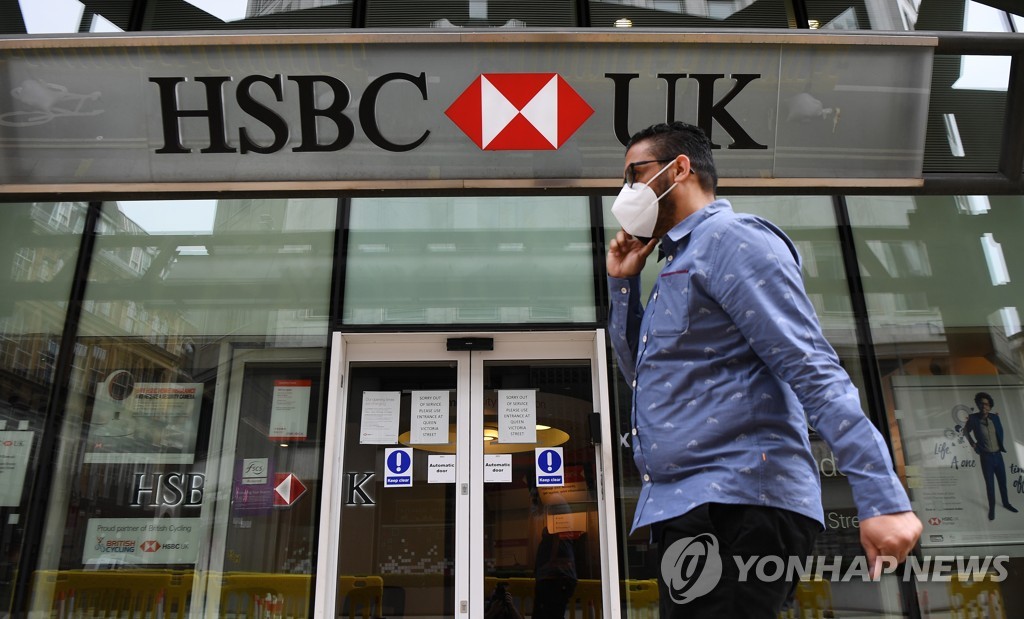 지난 4일 영국 런던 중심가에서 한 시민이 마스크를 쓴 채 HSBC 은행 지점 앞을 지나가고 있다. [EPA=연합뉴스 자료사진]