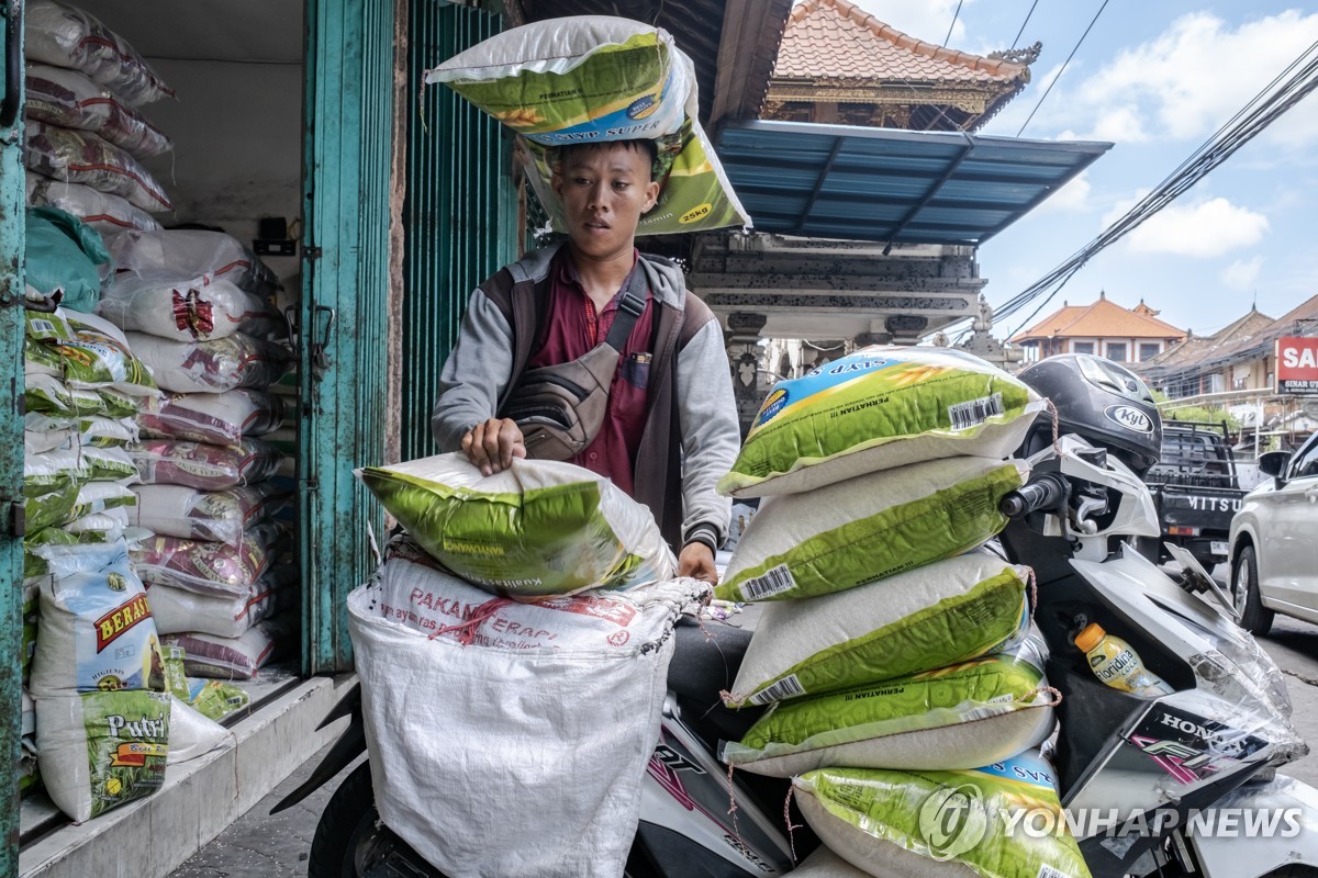 지난 26일 인도네시아 발리주 덴파사르에서 한 남성이 쌀자루를 나르고 있다. 
