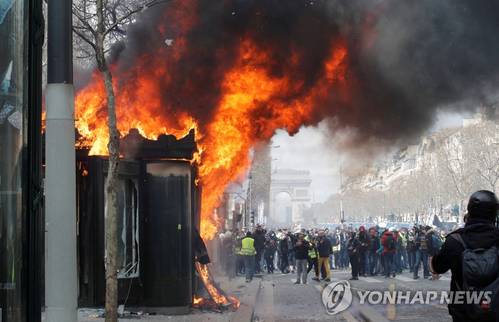 16일 노란 조끼 시위가 열린 프랑스 파리 샹젤리제 거리의 신문 가판대가 불타고 있다. [로이터=연합뉴스]