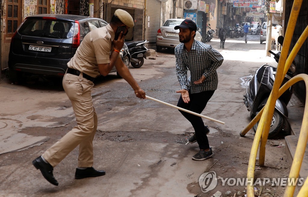 봉쇄령 위반자를 막대기로 때리는 인도 경찰관