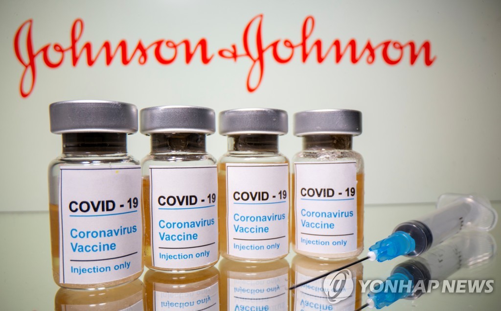 미국 제약사 존슨앤드존슨(J&J) 로고 앞에 신종 코로나바이러스 감염증(코로나19) 백신이라고 쓰인 병이 놓여있는 이미지. [로이터=연합뉴스 자료사진]