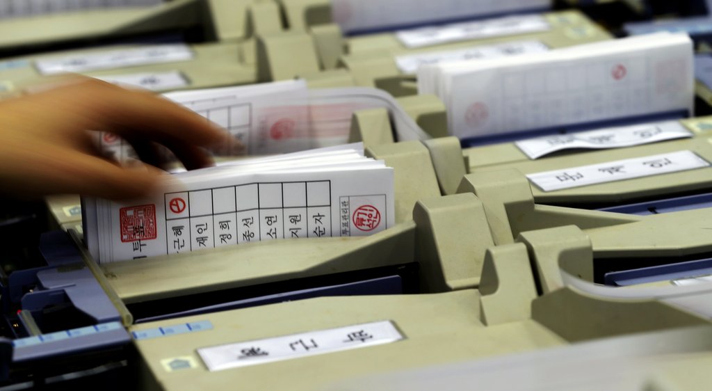 제18대 대통령 선거를 마친 19일 한 개표소에서 개표요원이 박근혜 후보가 찍힌 투표용지 묶음을 투표지 분류기에서 뽑고 있다. (자료사진)