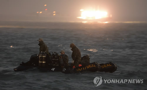 합동구조팀 잠수사들이 세월호 침몰 1주일째인 지난 22일 저녁 채낚기 어선이 불을 밝힌 가운데 현장 수색작업을 벌이고 있다. (해군 제공)