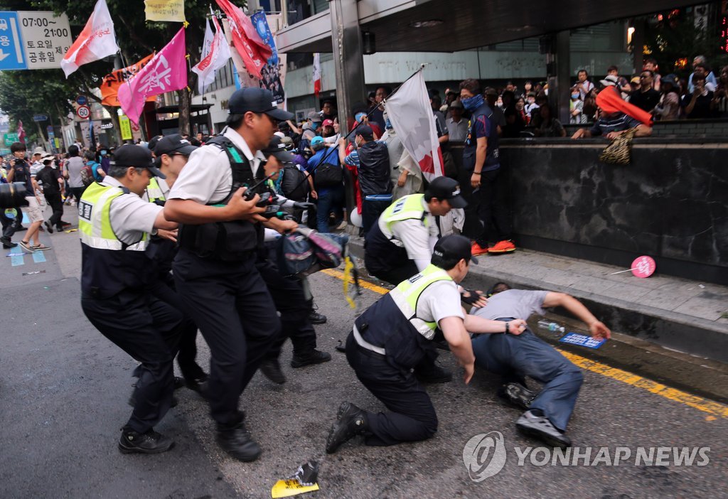 28일 경찰관들이 쌀 전면개방에 반대하며 서울 종로를 점거한 시위 참가자를 연행하고 있다. 