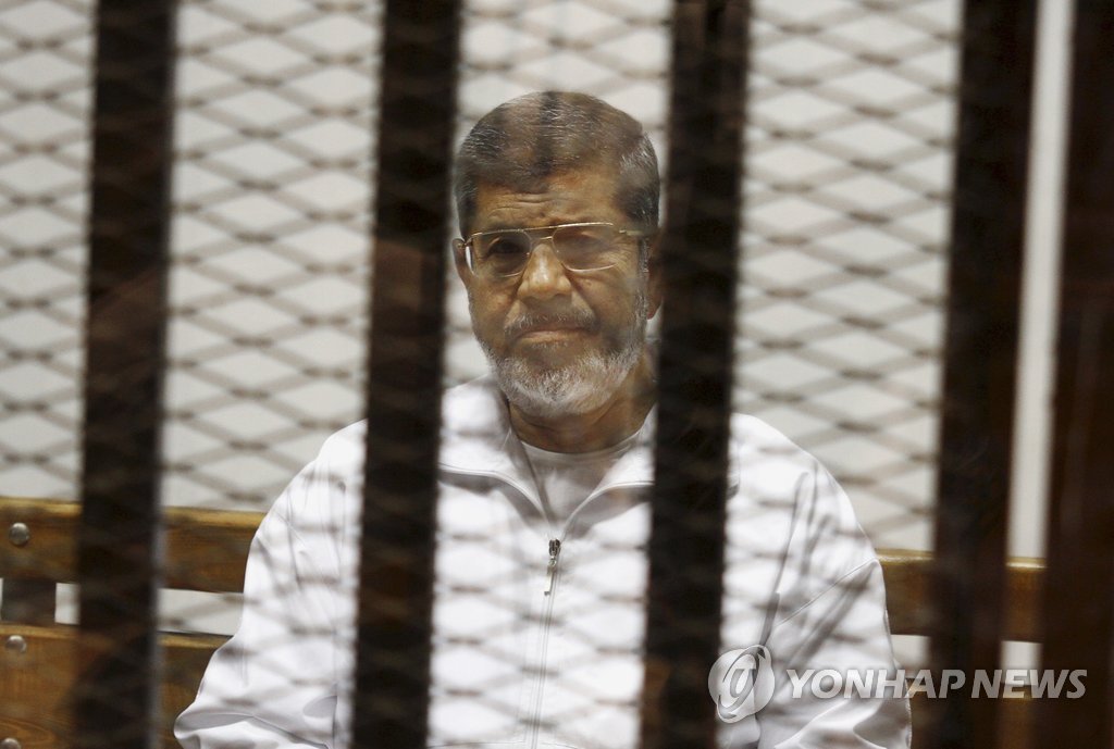 무르시 이집트 전 대통령이 지난해 5월 8일 카이로의 경찰학교 법정 피고인 감금소에 앉아있는 모습. (AP=연합뉴스 자료사진)