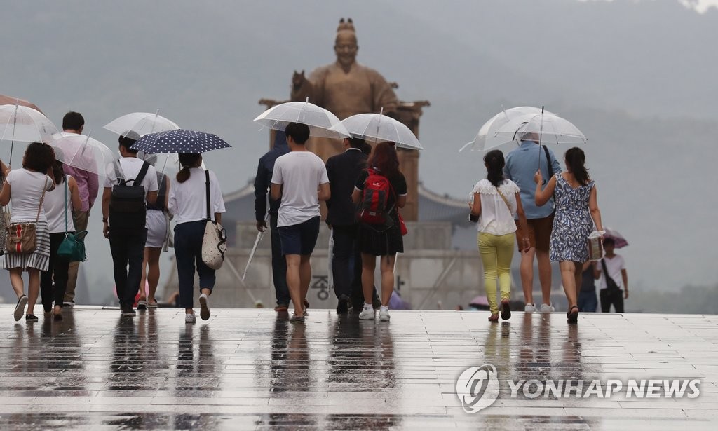 소나기가 내려 광화문광장에서 우산을 쓴 시민들이 길을 걷고 있다. [연합뉴스 자료사진]