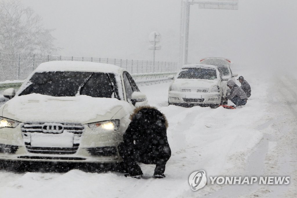 영동 폭설…체인 치는 운전자 (속초=연합뉴스) 이종건 기자 = 강원 북부에 대설경보가 내려진 30일 오후 동해고속도로 속초요금소 인근에서 운전자들이 도로에 차를 세우고 체인을 치고 있다. 2017.1.30 momo@yna.co.kr