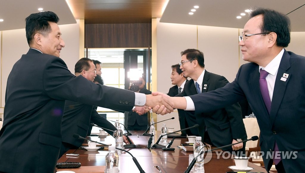 実務会談で握手を交わす韓国（右）と北朝鮮の出席者（統一部提供）＝１７日、ソウル（聯合ニュース）