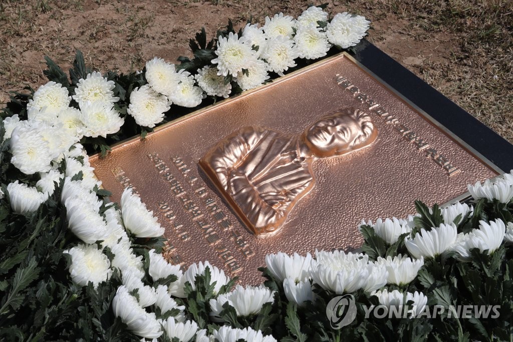 국화에 둘러싸인 고창석 교사 추모비