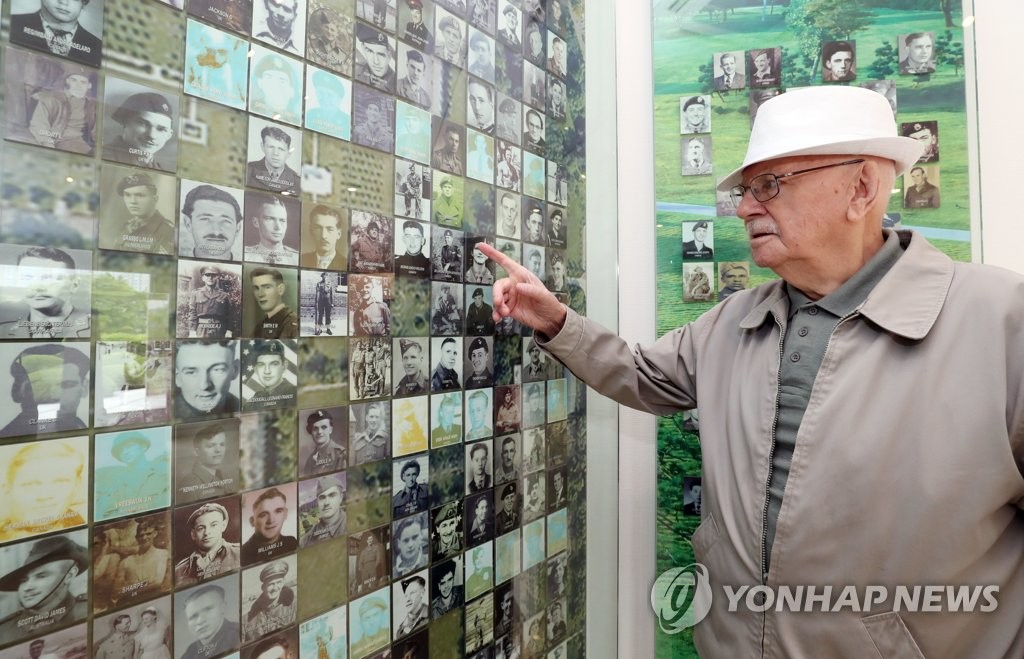 한국전 전사자 사진 보는 영국군 노병