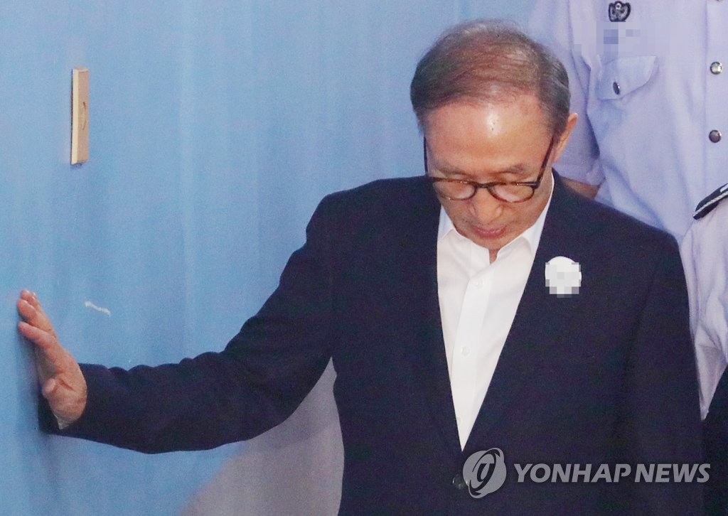 벽 짚고 법정향하는 이명박