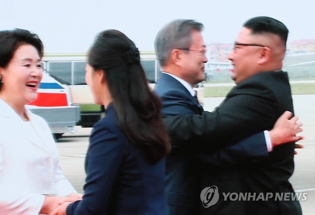 The captured image of a live broadcast from Pyongyang shows South Korean President Moon Jae-in (2nd from R) and North Korean leader Kim Jong-un embracing each other shortly after Moon's arrival in the North Korean capital on Sept. 18, 2018, for the leaders' third inter-Korean summit. (Yonhap)