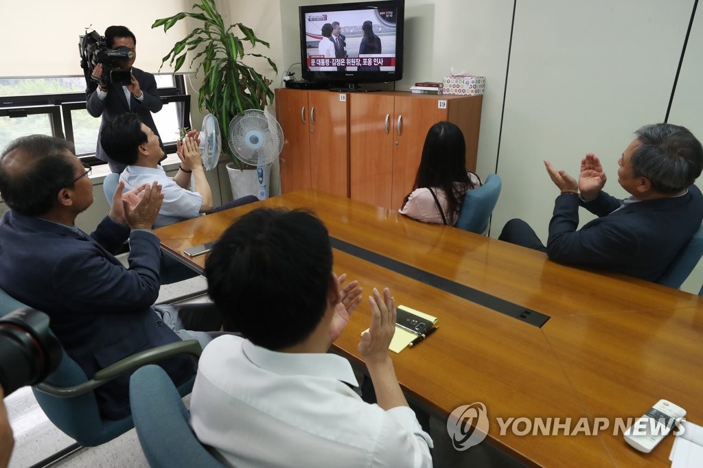 South Korean businesspeople who had operated factories at the now-shuttered joint industrial complex in North Korea's border city of Kaesong watch a TV live broadcast of President Moon Jae-in's arrival at Pyongyang for a three-day summit visit in their office in Seoul on Sept. 18, 2018. (Yonhap)