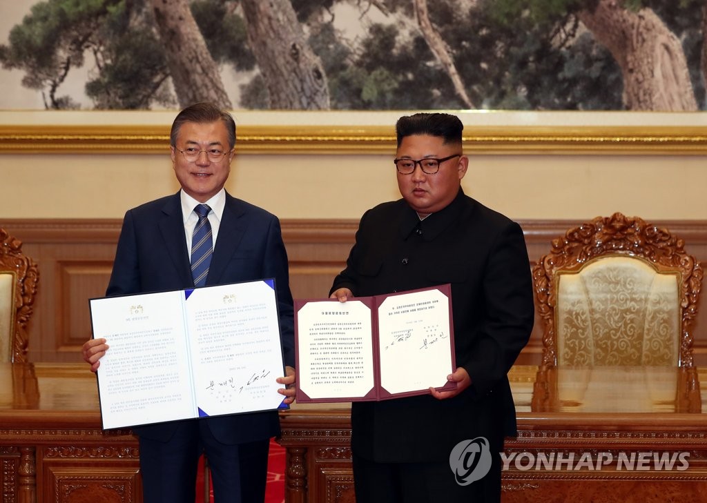 South Korean President Moon Jae-in (L) and North Korean leader Kim Jong-un pose with their summit agreement in Pyongyang on Sept. 19, 2018. (Joint Press Corps-Yonhap)
