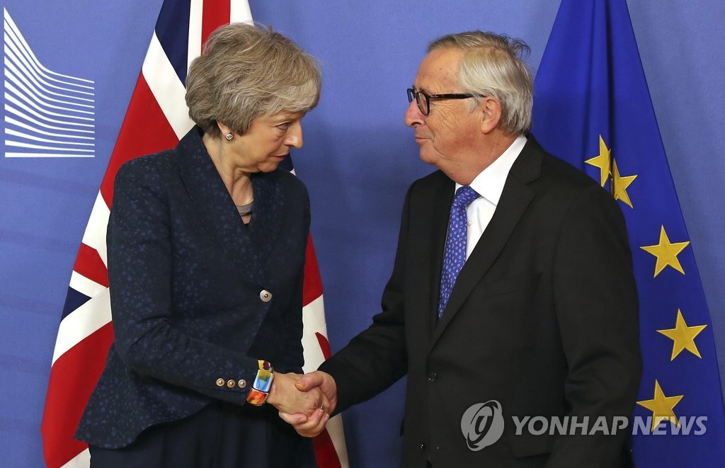악수하는 융커 EU 집행위원장(우)과 메이 영국 총리(좌)
