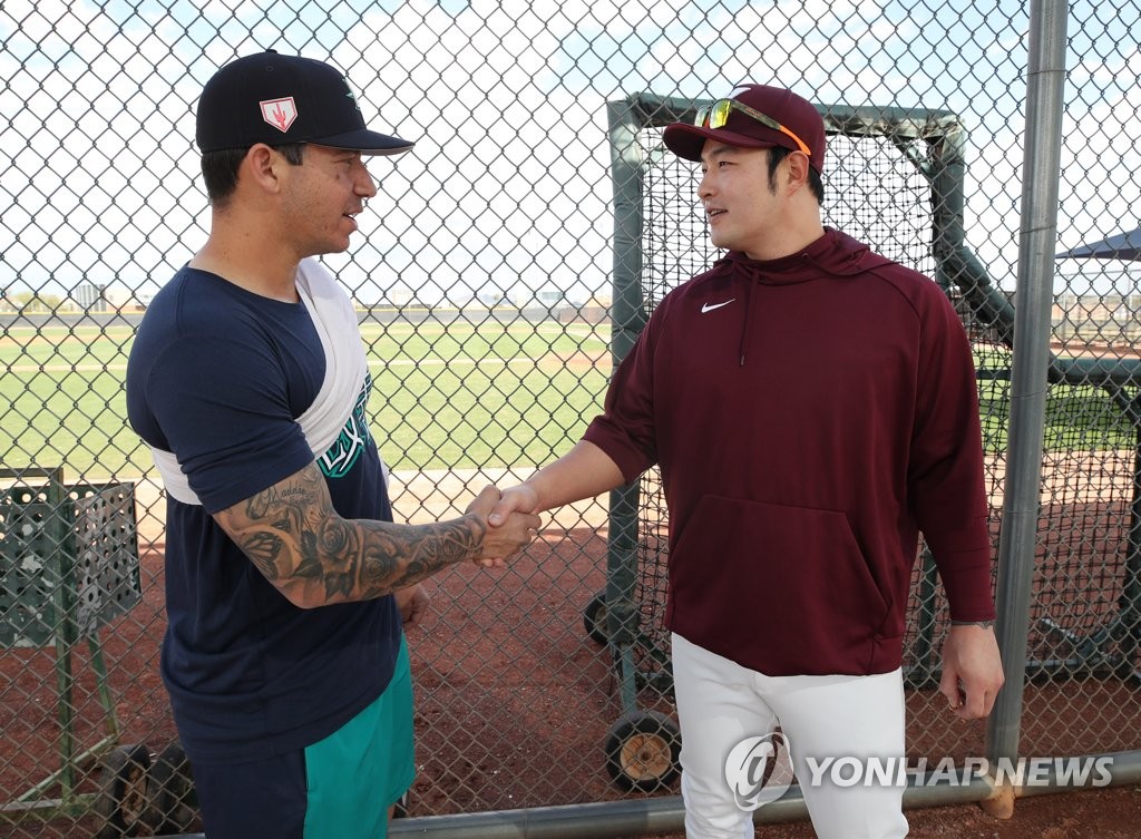 Park Byung-ho of the Kiwoom Heroes (R) shakes hands with his former Minnesota Twins teammate Tommy Milone, currently with the Seattle Mariners, at Peoria Sports Complex in Peoria, Arizona, on Feb. 17, 2019. (Yonhap)