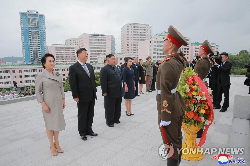 Chinese President Xi Jinping (2nd from L), North Korean leader Kim Jong-un (3rd from L) and their respective wives -- Peng Liyuan (L) and Ri Sol-ju (4th from L) -- pay homage at the Friendship Tower, a symbol of their countries' alliance, in Pyongyang on June 21, 2019, in this photo released by the North's official Korean Central News Agency. (For Use Only in the Republic of Korea. No Redistribution) (Yonhap)