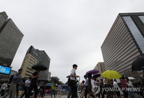 우산을 든 출근길 시민들이 서울 광화문네거리를 지나고 있다.