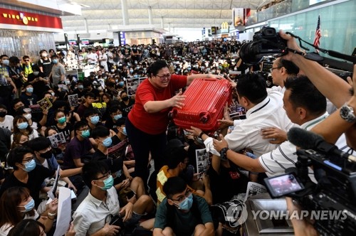 출국장 들어가려 '가방 도움' 받는 홍콩공항 여행객