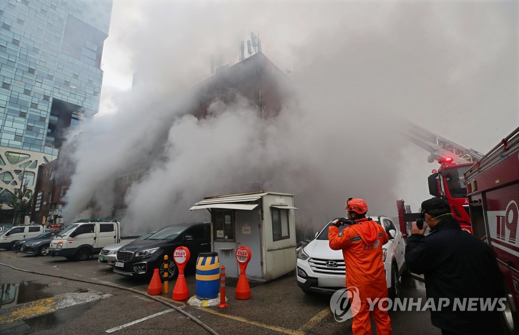 건물에서 피어오르는 화재 연기