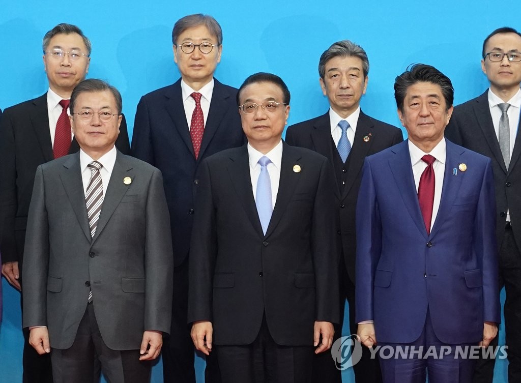 韓中日首脳会談に合わせて中国・成都で開催された3カ国ビジネスサミットで記念撮影する(前列左から)韓国の文在寅(ムン・ジェイン)大統領、中国の李克強首相、日本の安倍晋三首相=24日、成都(聯合ニュース)