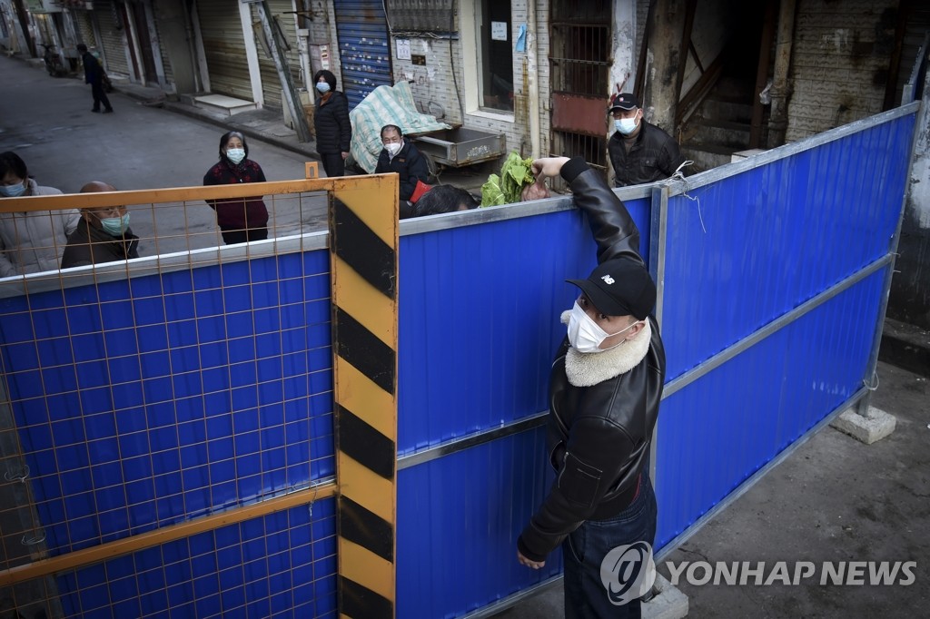 주택 봉쇄 바리케이드 너머로 식료품 전달하는 중국인