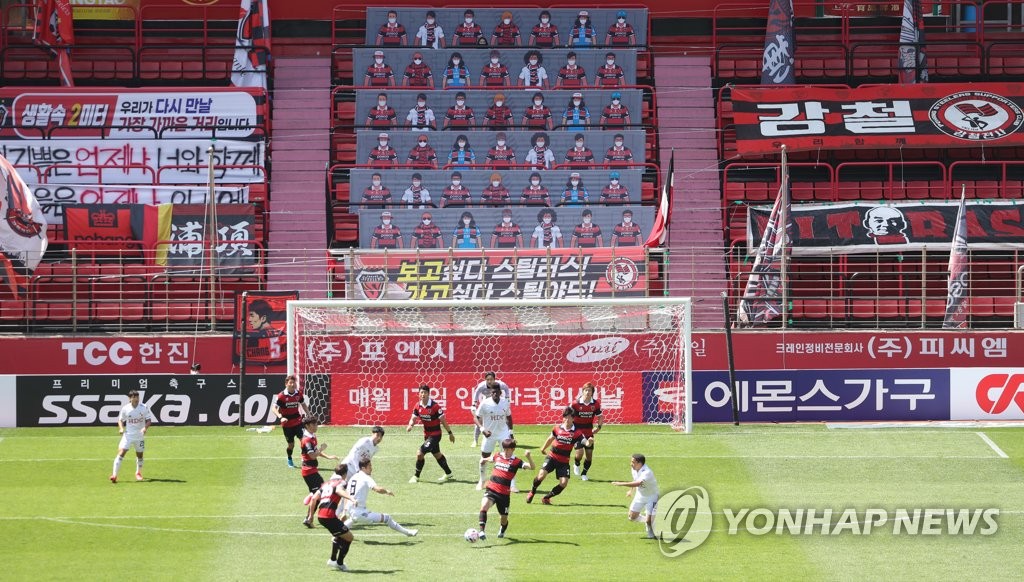 This file photo from May 10, 2020 shows a K League 1 match between Pohang Steelers and Busan IPark being played at an empty Pohang Steel Yard in Pohang, 370 kilometers southeast of Seoul, with banners showing mask-clad fans covering up seats. (Yonhap)