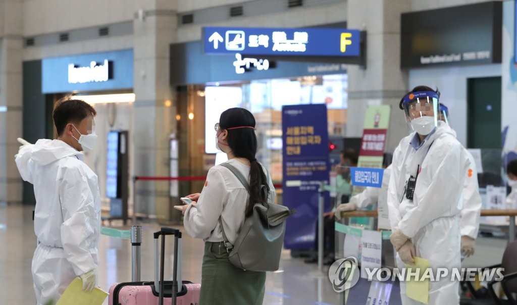 Health workers guide an international arrival through quarantine measures at Incheon International Airport, South Korea's main gateway west of Seoul, on June 23, 2020. (Yonhap)